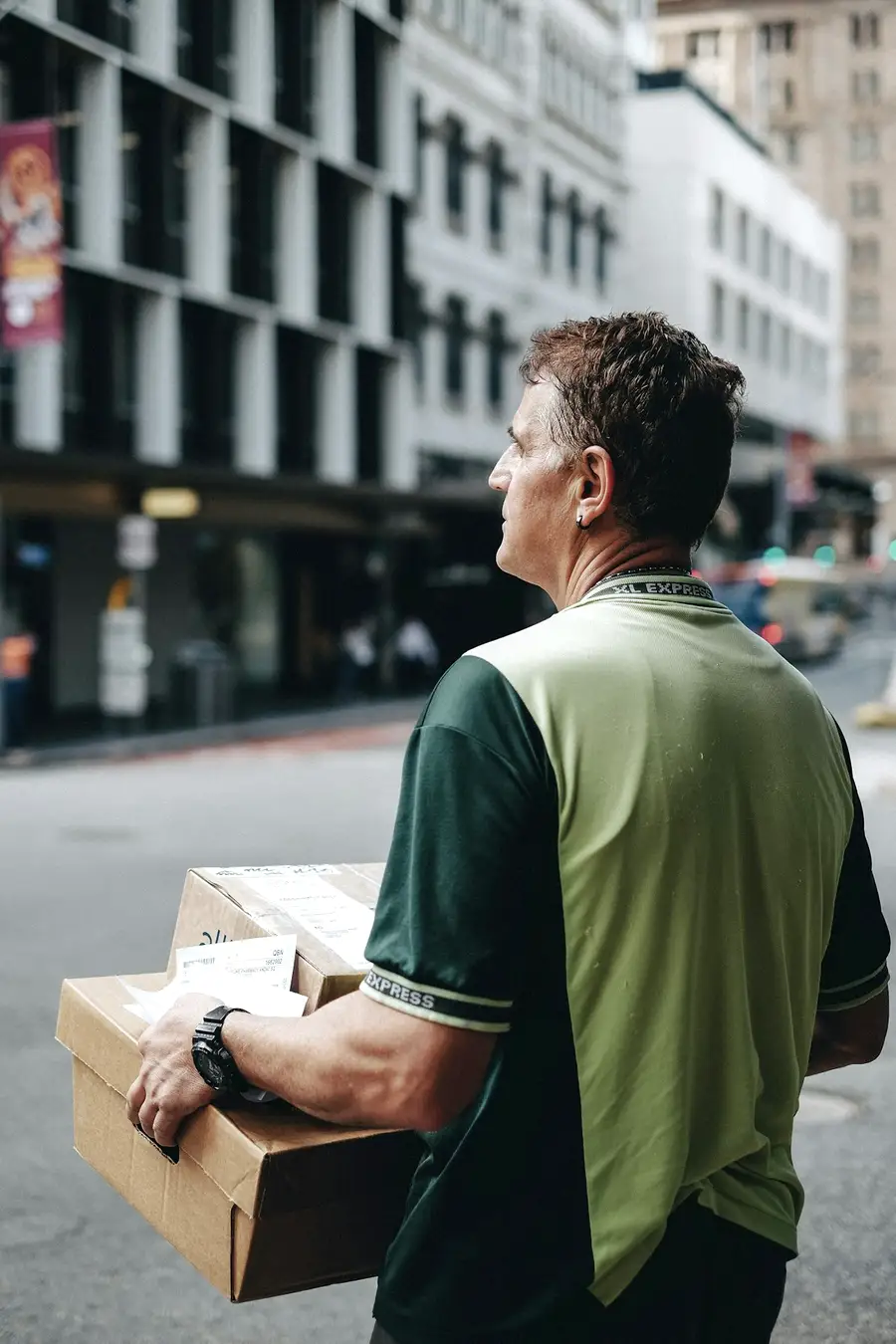 Transportista descargando cajas de su furgón en la calle