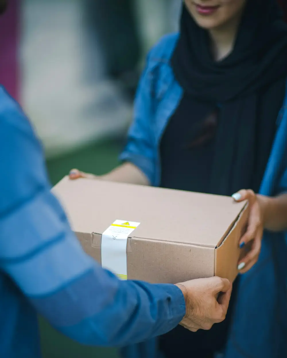 Manos entregando una caja a un cliente